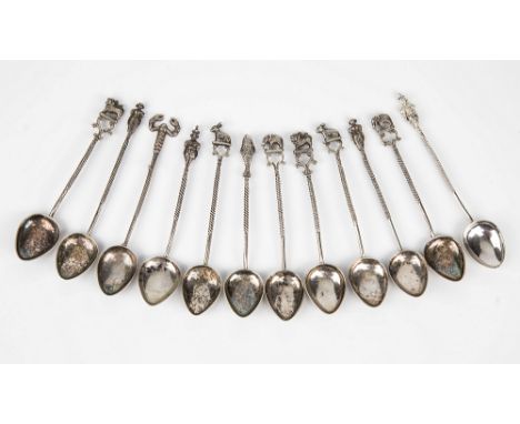 A set of twelve Indian silver coffee spoons early 20th century, with teardrop bowls, twist stems and figural and animal termi