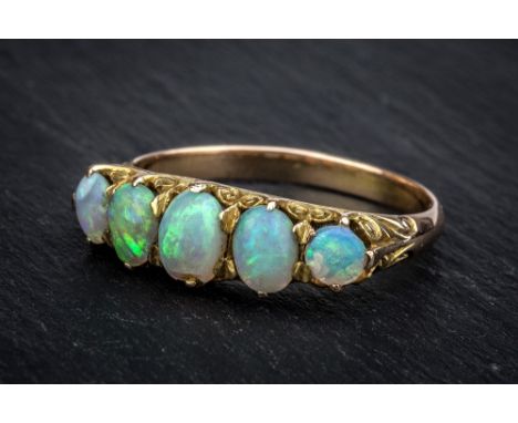 An antique yellow gold and opal five stone ring early 20th century, the scrollwork setting with five oval graduated opals, ri