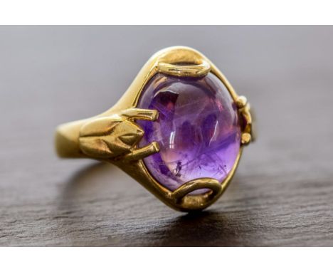 A Catherine Best 18ct yellow gold and amethyst ring the cabochon amethyst in an Art Nouveau influenced setting with foliate d