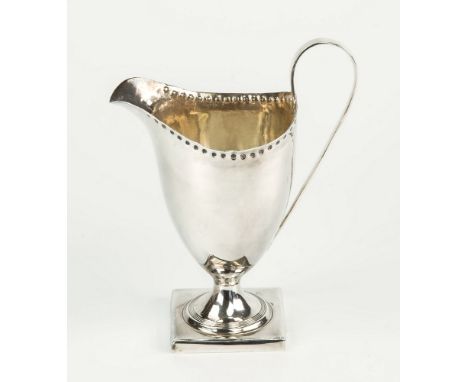 A George III silver helmet cream jug Peter, Ann & William Bateman, London 1799, with punch beaded rim, high scroll handle and