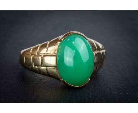 A 9ct gold and green jade style stone ring the green cabochon stone within snakeskin effect shoulders, ring size W.