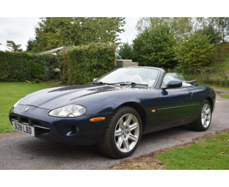 A 1998 Jaguar XK8 convertible, registration number S128 LBD, dark blue.  Launched in 1996 alongside its coupé stable mate the