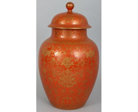 A GOOD QUALITY CHINESE CORAL GROUND PORCELAIN VASE & COVER, the sides decorated with formal scrolling lotus, baskets of peach