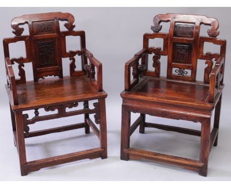 A PAIR OF CHINESE CARVED HARDWOOD CHAIRS, each back rest carved with a figural and with an archaic pattern panel, the friezes