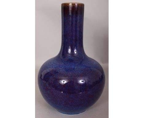 A CHINESE FLAMBE GLAZED PORCELAIN BOTTLE VASE, the streaked glaze thinning to brown at the neck rim, the base with a Qianlong