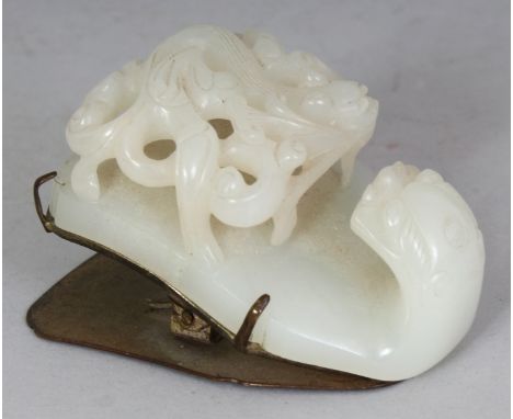 A GOOD QUALITY 18TH/19TH CENTURY CHINESE CELADON JADE BUCKLE, with a silvered copper mount, the jade well carved with a drago