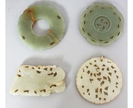 A GROUP OF FOUR CHINESE JADE PENDANTS, the largest 2.3in diameter. (4)