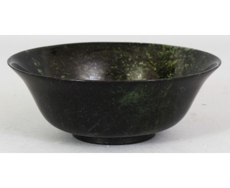 A CHINESE TRANSLUCENT JADE LIKE BOWL, with an everted rim, the predominantly dark green body with lighter areas, 5.9in diamet