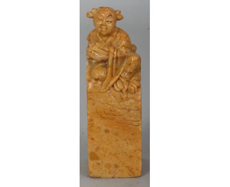 A CHINESE SOAPSTONE SEAL, surmounted by a cloud borne deity, 3.9in high.