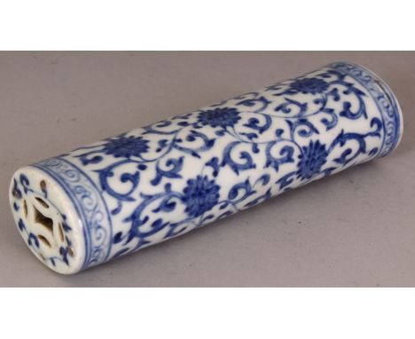 A CHINESE BLUE & WHITE PORCELAIN WRIST REST, of oval section with pierced ends, decorated with formal scrolling lotus, one en