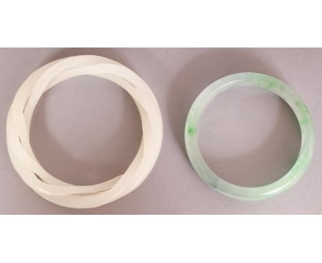 A CHINESE WHITE JADE TRIPLE STRAND BANGLE, 3.25in diameter; together with an apple-green jade bangle, 2.7in diameter.
