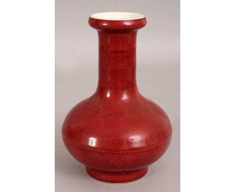 A CHINESE SANG-DE-BOEUF PORCELAIN BOTTLE VASE, the neck with ribbing, the base with a Yongzheng seal mark, 6.7in high.