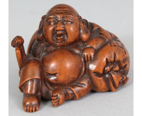 A JAPANESE MEIJI PERIOD CARVED WOOD NETSUKE OF HOTEI, unsigned, holding a fan and leaning backwards against his voluminous ba