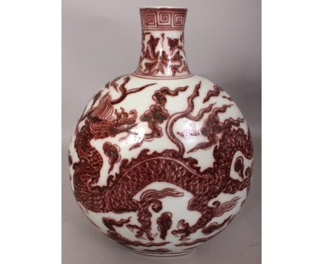 A CHINESE MING STYLE COPPER RED PORCELAIN MOON FLASK, decorated with two dragons amidst cloud and flame scrolls, 8.9in wide a