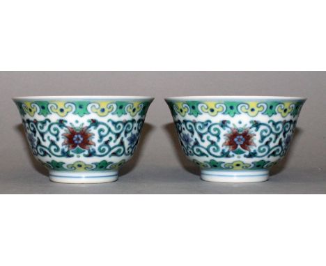 A SMALL PAIR OF CHINESE DOUCAI PORCELAIN BOWLS, each decorated with a formal band of scrolling lotus between ruyi borders, ea