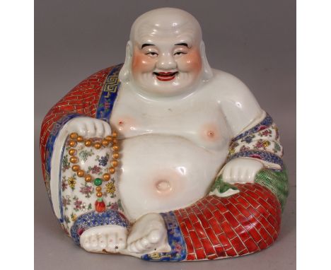 A LARGE CHINESE PORCELAIN FIGURE OF BUDAI, seated with cheerful expression and holding a string of beads, the base unglazed a