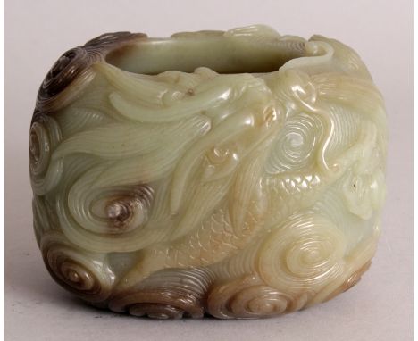 A CHINESE CELADON JADE BRUSHWASHER, decorated in relief to the sides with a dragon amidst swirling cloud scrolls, the stone w