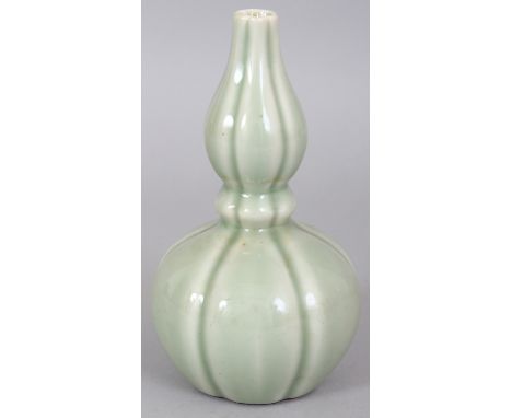 A CHINESE CELADON DOUBLE GOURD PORCELAIN VASE, of fluted hexafoil section, the base with a Qianlong seal mark, 6.25in high.