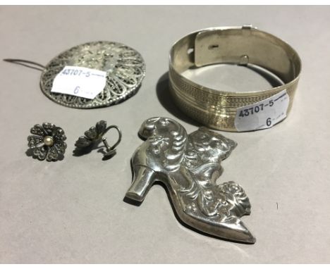 A silver cat in boot brooch, a filigree Egyptian brooch, a pair of silver earrings and a silver cuff bangle (65.3 grammes)