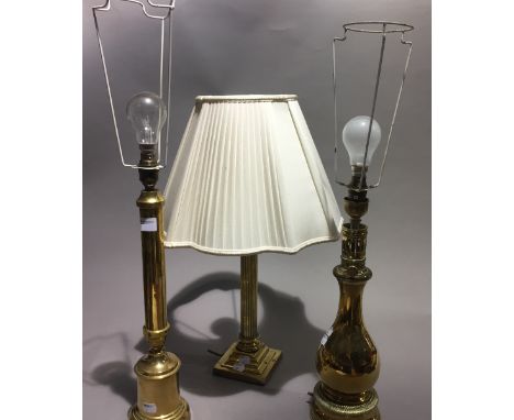 A brass lamp base, together with two others