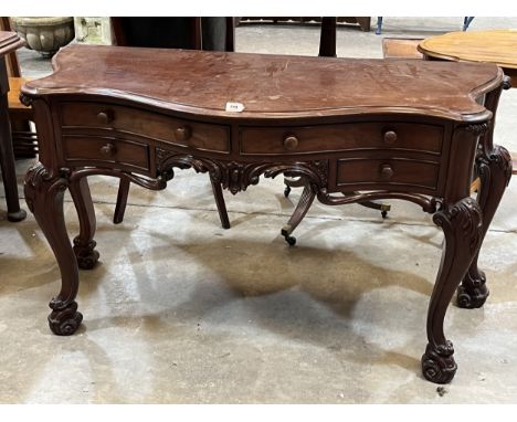A Victorian mahogany serpentine console table, the moulded top over four drawers and carved apron, on acanthus carved cabriol