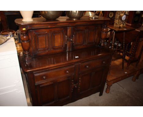An Ercol court cupboard fitted two drawers and cupboards below 