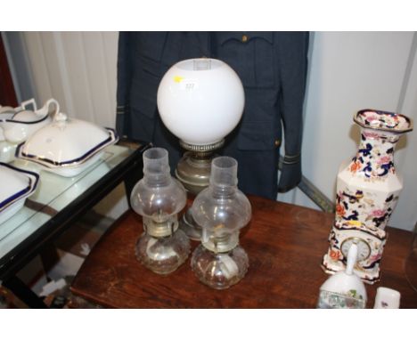 A brass oil lamp and two clear glass oil lamps 
