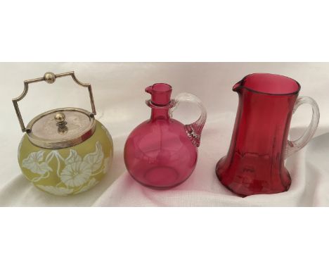 A yellow cameo cut glass biscuit barrel in the style of Galle with silver plated mounts and two cranberry glass jugs, tallest