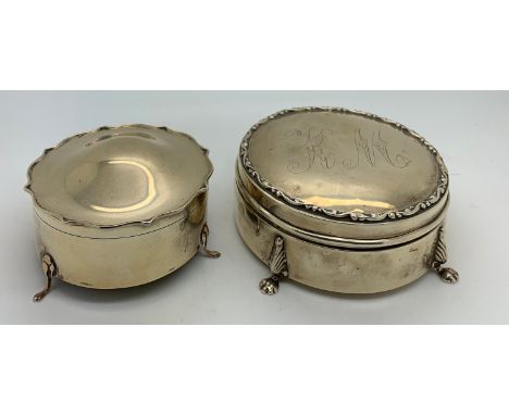 Two lidded hallmarked silver dressing table boxes. One Birmingham 1919 with K M inscribed to the top. 10cms d raised on paw f