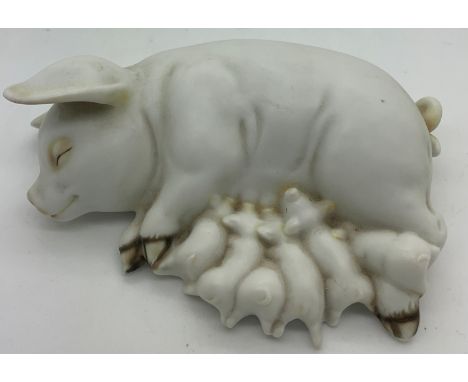 A ceramic recumbent pig suckling piglets. 15cms l.Condition ReportGood condition.