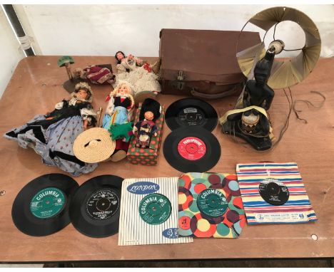 A miscellany to include 45rpm singles, 1960's era, International dressed dolls, a chalk African tribal figure table lamp and 