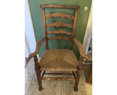 An 18thC elm ladder back rush seated chair.