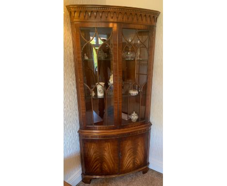 A 20thC mahogany corner cupboard with 2 glazed doors over 2 solid doors and a pull out shelf to front. Approx. 188cm h x 62cm