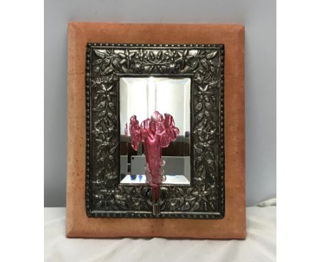 An embossed silver plate framed wall mirror with a velvet lined back with a cranberry glass flute to the front. Mirror 15cm w
