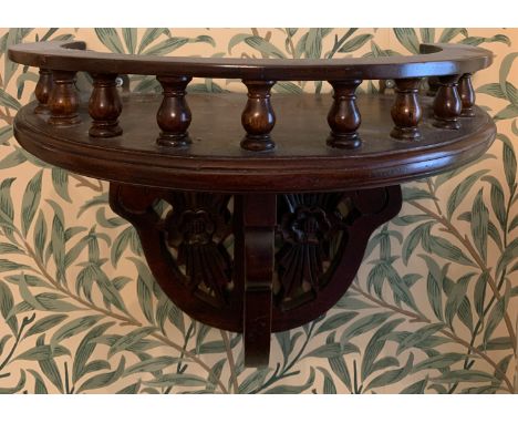 A 20thC mahogany wall shelf with decorative carving and gallery top. 36 w x 40cms h.