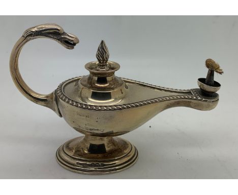 A hallmarked silver novelty table lighter formed as an oil lamp. Birmingham 1912.15cms l x 9.5cms h.Total weight 126.6gms.Con