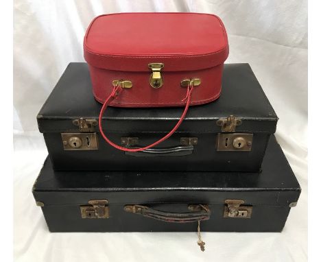 Two black compressed cardboard suitcases 60 x 35cms and 50 x 29cms together with a red vanity case.Condition ReportSurface ru