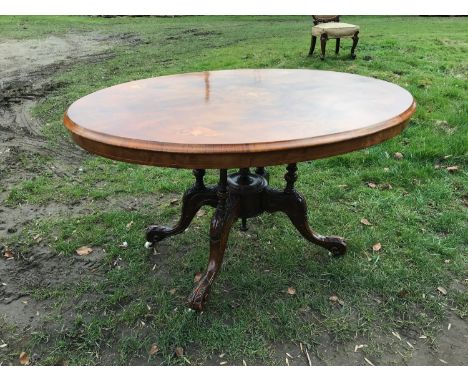 Victorian walnut inlaid oval tip top table with carved base and pot castors. 129cm x 97cm, approx 71cm h.Condition ReportFair