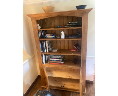 A 4 shelf pine bookcase with cupboard to base. 205 h x 134 w x 43cms d.
