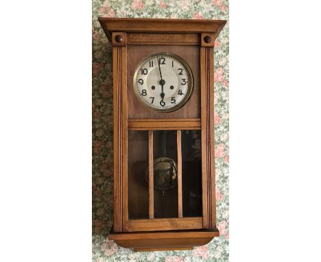 Oak wall clock with visible brass pendulum. 68 x 32 x 17cms d.