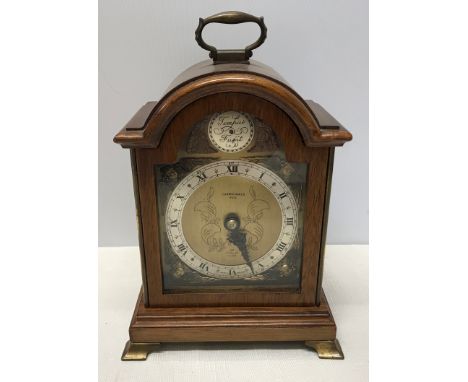 A mahogany cased Elliot mantle clock with a cherub decorated brass face. Retailed by Carmichaels of Hull. Case height approx.