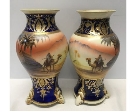 A pair of Japanese Noritake decorative vases 25cm h with blue ground gilded with scenes of Arabian Desert.Condition ReportGil