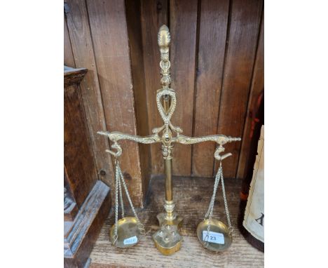 A set of brass scales with four weights. 