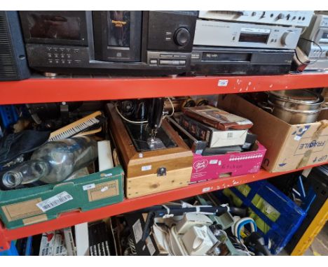 A Singer sewing machine and three boxes of mixed items including spotlight, large empty whisky bottle, personal massager item