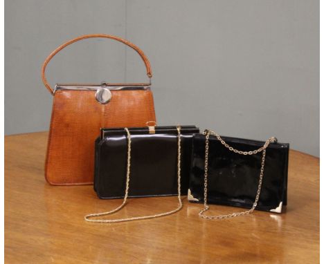 A vintage lizard skin handbag and two black patent leather bags with chain shoulder straps