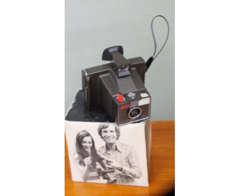 A Polaroid Super Swinger hand camera in original box