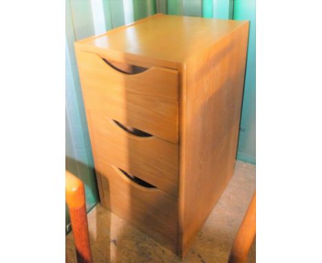 A simple light coloured three drawer cabinet