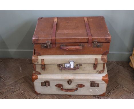A vintage leather suitcase, a canvas suitcase and one other