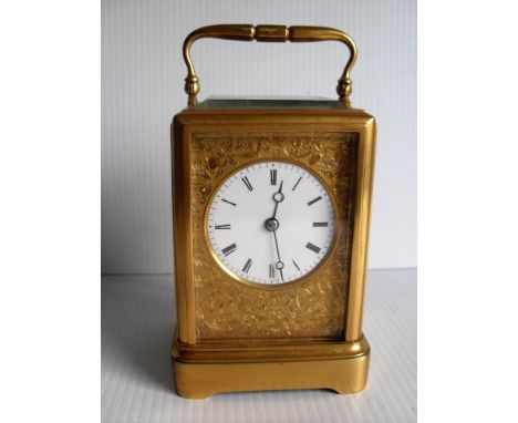 A gilt brass striking carriage clock with white 5.5 cm enamel dial, Roman numerals, blind fretwork to gilt metal mask with a 