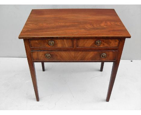 A Georgian oblong mahogany occasional table with two short and one long drawer, ring-turned brass handles on square tapering 